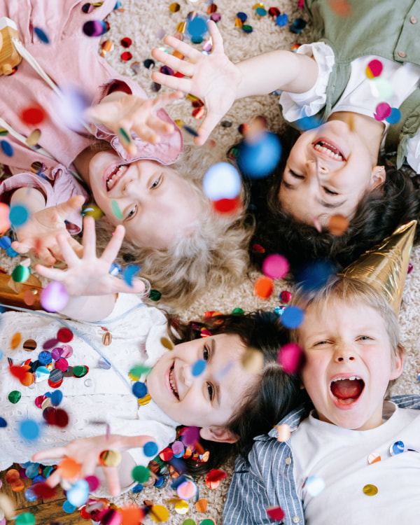 four children, excited and playing with confetti