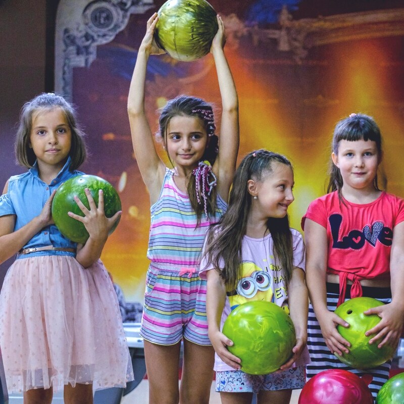 four children holding bowling balls